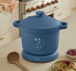 Blue rice cooker on a kitchen counter with a digital display and control panel.